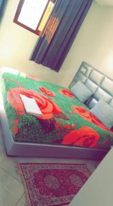 达赫拉Hotel Soukina的红色鲜花的房间的一张床位