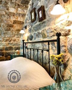 DūmāStone Cellars的一间卧室设有一张床和石墙