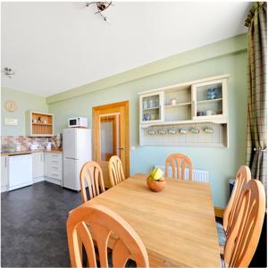 戈尔布里奇The Arches, Borthwick Mains Farm,的厨房以及带木桌和椅子的用餐室。