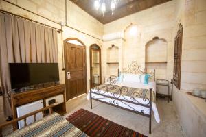 尚勒乌尔法Hayatlı Konak的一间卧室配有一张床和一台平面电视