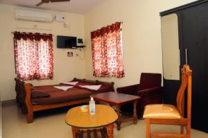 科鲁鲁Shwetha Lodge的卧室配有1张床、1张桌子和1把椅子