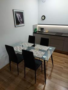 奥普尔Apartamenty Lawendowy Zakątek 5的一张带四把椅子的玻璃桌和厨房