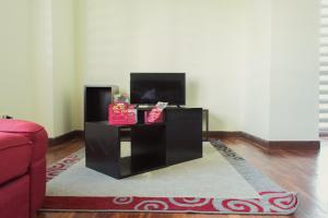 拉巴斯Luxstone Executive & Suites的客厅配有电视和桌子