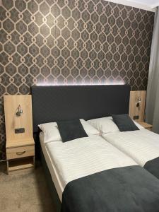 普罗斯捷约夫Penzion Ema B&B的一间卧室设有两张床,墙上设有床头板