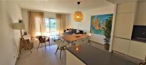 阿尔布费拉Albufeira beach apartment的厨房以及带桌子和沙发的客厅。