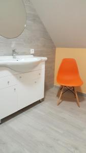 Brodnica DolnaWilla Brodnica的带盥洗盆的浴室内的橙色椅子