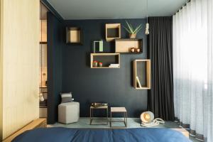 根特Boutique B&B Graaf的一间卧室设有蓝墙、书架和一张床
