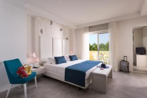 里米尼阿索托丽亚套房酒店的一间卧室配有一张大床和一张蓝色椅子