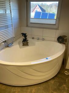 普雷罗Maisonette zum Weststrand的带窗户的浴室内的白色大浴缸