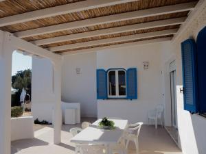 托雷苏达Villa Oltremare的庭院设有蓝色百叶窗和桌椅