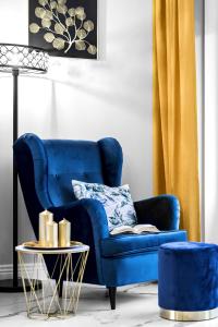 什切尔克Apartament Zacisze z prywatną sauną的客厅配有一张蓝色的沙发,配有一张桌子