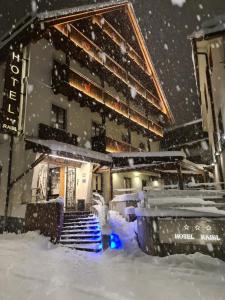 塔尔维西奥Hotel Raibl e Appartamenti的积雪中积雪的建筑物