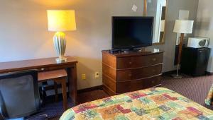 玛丽埃塔市Magnuson Hotel Marietta的酒店的客房 - 带一张床、一台电视和一张书桌