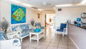 克利尔沃特比尔埃尔海滩度假汽车旅馆的客厅配有蓝色和白色的家具和绘画