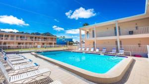 克利尔沃特比尔埃尔海滩度假汽车旅馆的一个带椅子的游泳池和一间酒店