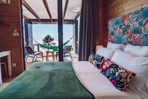 卡列塔Calheta Glamping Pods - Nature Retreat的一间卧室配有一张床,阳台配有吊床