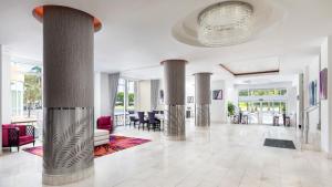迈阿密迈阿密YVE酒店的大堂设有圆柱、椅子和吊灯