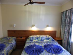 彭特派因诺福克岛全景海滨公寓的一间卧室配有两张带蓝色枕头的床。