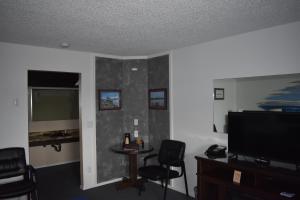 班敦Lighthouse Cove Inn的客厅配有桌椅和平面电视。