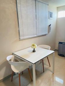 庞塞Charming Retreat with Patio Access and FREE Laundry的一张带两把椅子的白色桌子和花瓶