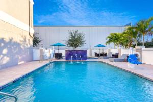 坦帕坦帕中心拉金塔旅馆及套房酒店的一个带蓝色椅子和遮阳伞的游泳池