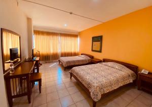 马查拉Hostal Solar Del Puerto的酒店客房配有两张床和一张书桌