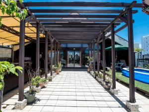 北谷町冲绳索尔镇公寓式酒店的一个带盆栽和游泳池的有盖走道