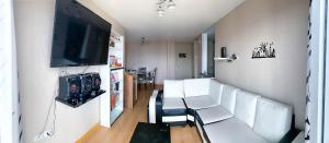 利马Vista Ashul Apartment 02 dormitorios的客厅配有白色椅子和平面电视