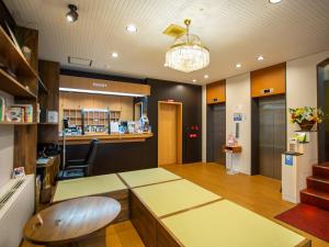 大阪卡尼尤西旅馆的一间设有桌子和椅子的等候室