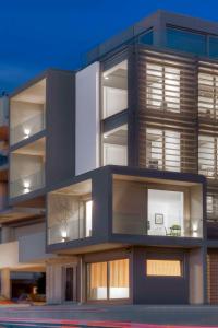 雅典Verde Apartments的大型公寓大楼设有许多窗户