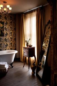 阿宾登王冠与蓟酒店的带浴缸的浴室和窗户。