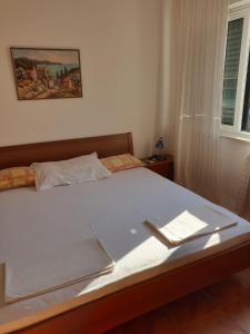 特尔帕尼Sunny place的一间卧室配有一张带白色床单的床和一扇窗户。