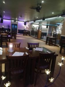 道格拉斯堡市场酒店 的餐厅设有木桌、椅子和紫色照明