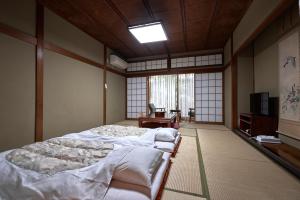 金泽山室日式旅馆的一间设有两张床和电视的房间