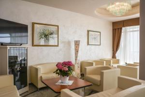 利莫内-苏尔加达HOTEL ASTOR的客厅配有椅子和鲜花桌
