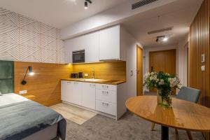 科沃布热格Seaside Apartaments Deluxe 627的厨房以及带桌子和床的用餐室。