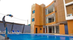 科托努Hotel La Casa Cielo的大楼前设有游泳池的酒店