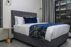 SandtonResidence at Montego的一间卧室配有一张带蓝色和金色毯子的床