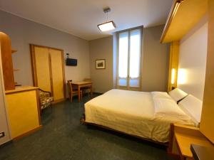 都灵丽培缇酒店的一间卧室配有一张床、一张桌子和一个窗户。