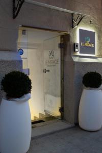 雷焦卡拉布里亚Le Mirage boutique的两个白花瓶坐在商店门前