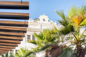 利雅德Vittori Palace Hotel and Residences的前面有棕榈树的建筑