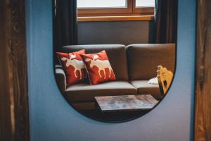 巴德小基希海姆Nordic Lodge的一张带枕头和桌子的沙发的镜子反射