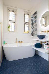 WagenbergB&B d'Ouwe Grutter的白色的浴室设有浴缸和水槽。
