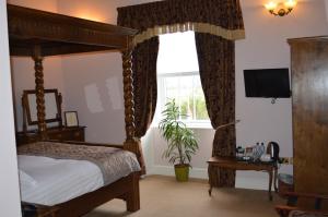 Mallwyd布里根茨宾馆的一间卧室设有天蓬床和窗户。