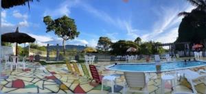 博阿维斯塔Pousada Country K的一个带五颜六色椅子的游泳池和一个游泳池