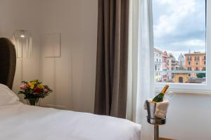 罗马Mercure Roma Centro Termini的酒店客房设有一张床和窗户,窗户内装有一瓶葡萄酒