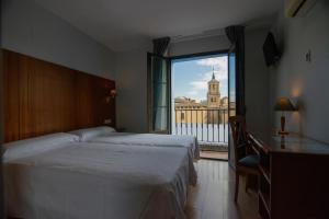 萨拉戈萨西斯帕尼亚酒店的酒店客房设有两张床和大窗户。