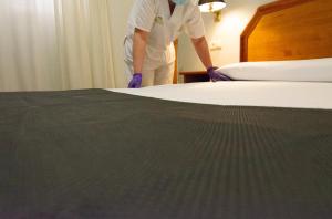 萨拉戈萨西斯帕尼亚酒店的一个人在旅馆房间做床