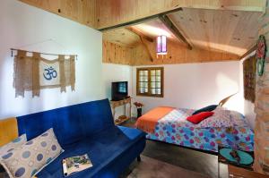 维奥康德马奥Karunâ的一间卧室配有蓝色的沙发和一张床