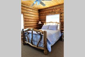 埃斯卡兰特Red Rock Ranch Log Cabin: Large, Fully Furnished的小木屋内一间卧室,配有一张床